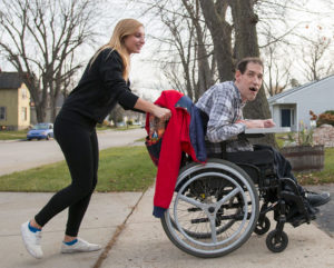 A covey client being pushed in a wheelchair.