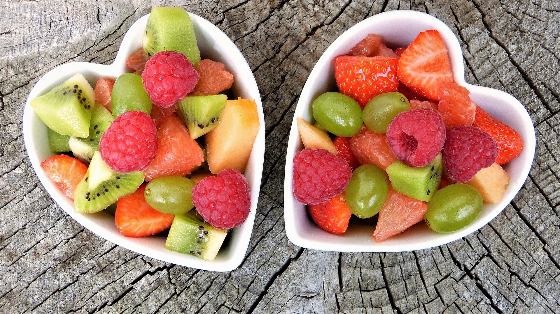 Fresh fruit in two heart shaped bowls.