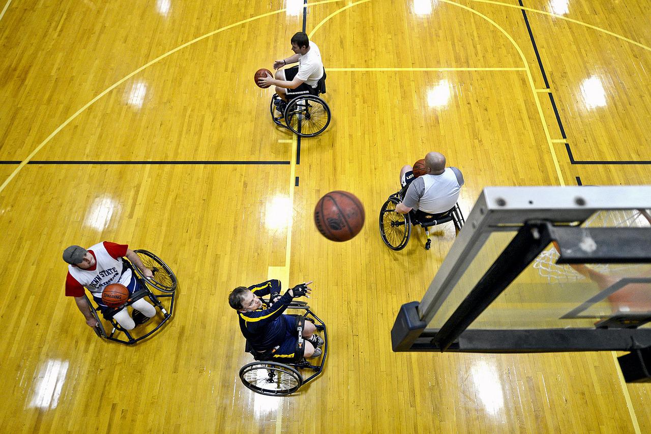 Four people in wheelchairs playing basketball.